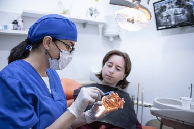 bir hasta ile konuşan kadın diş hekimi