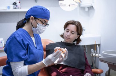 bir hasta ile konuşan kadın diş hekimi