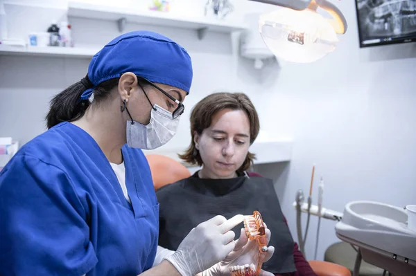 bir hasta ile konuşan kadın diş hekimi