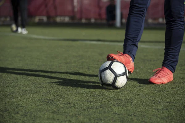 Close up of legs with a ball in a football ground — Stock Photo, Image