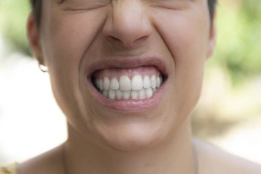 Close view portrait of woman with angry grin clipart