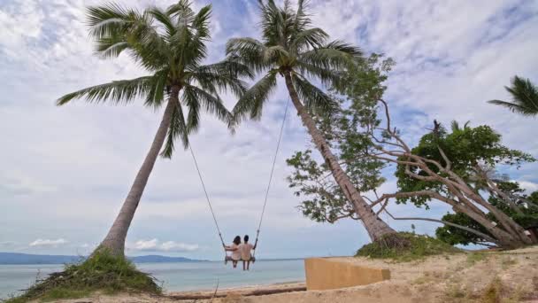 Ein Junges Paar Das Einem Tropischen Strand Auf Einer Schaukel — Stockvideo