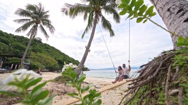 Una Joven Pareja Balanceándose Columpio Una Playa Tropical Pareja Enamorada — Vídeo de stock