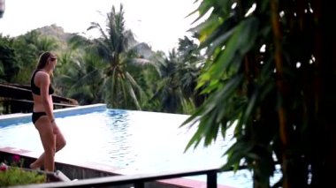 Havuzun kenarında kız dalmaya hazırlanıyor.