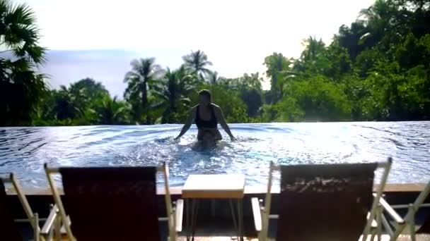 在热带岛屿上阳光明媚的日子里 两个女孩在室外游泳池玩耍 — 图库视频影像