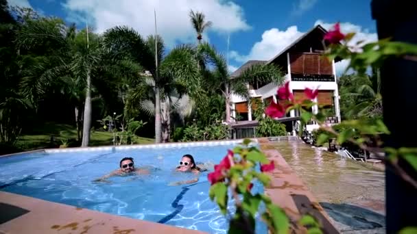 一对年轻夫妇在游泳池里游泳 — 图库视频影像