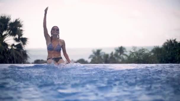 若くて美しい女の子熱帯の島にオープン空の下でプールに海に見えます 海を見下ろすプールで女性を浴び — ストック動画