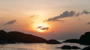 Güneş ufukta ayarlar. deniz günbatımı. bulutlar batımında gökyüzünde yüzen