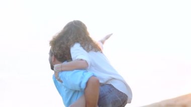 Genç, güzel bir kaç gün batımında bir kucaklama deniz kıyısı boyunca yürüyüş. Adam ve kız bir tropik adada balayına.