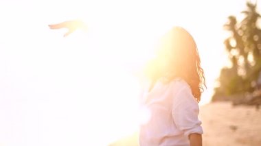 Günbatımında bir tropik ada kıyı yürüyen güzel genç kadın. Kumlu plaj gülümseyen üzerinde mutlu kız.