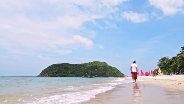 Homem Jovem Bonito Está Caminhando Pela Praia Uma Ilha Tropical — Vídeo de Stock