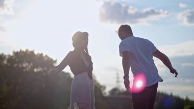 Adam ve kız mutlu bir şekilde açık havada vakit geçirirler. Aşk atlama ve spin ve gün batımı parkta etrafında aptal bir çift.