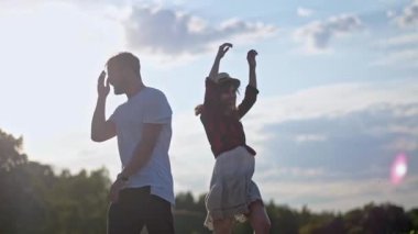 Adam ve kız mutlu bir şekilde açık havada vakit geçirirler. Aşk atlama ve spin ve gün batımı parkta etrafında aptal bir çift.