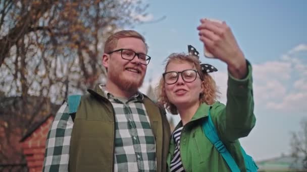 아름다운 부부는 가지에서 셀카를 찍습니다 핀란드 친구들은 전화로 자신의 사진을 — 비디오