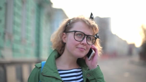 Una Chica Joven Bonita Con Gafas Está Hablando Por Teléfono — Vídeo de stock