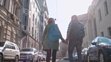 Sevgi dolu bir çift şehirde dolaşıyor. Genç bir aile dünyayı dolaşıyor. Eski şehirde yürüyor. Moskova avluları. Tarih Merkezi. Gözlüklü genç adam ve kadın. Eski şehri keşfeden sıradışı turistler. El ele gidiyorlar..