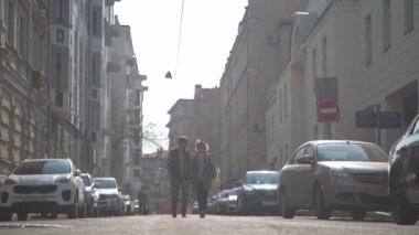 Sevgi dolu bir çift şehirde dolaşıyor. Genç bir aile dünyayı dolaşıyor. Eski şehirde yürüyor. Moskova avluları. Tarih Merkezi. Gözlüklü genç adam ve kadın. Eski şehri keşfeden sıradışı turistler. El ele gidiyorlar..