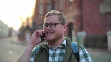 Sokakta genç, yakışıklı bir Fin adam duygusal telefonda konuşuyor. Cep telefonuyla mutlu bir şekilde konuşan bir adam. Genç işadamı sorunları telefonla çözüyor. Neşeli genç adam cep telefonuyla konuşuyor ve gülümsüyor. Mutlu adam. Kablosuz teknoloji. 