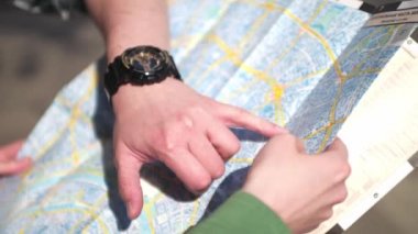 İki kişi haritaya bakıyor. Sevgi dolu birkaç turist bir yürüyüş rotası seçiyor. Moskova haritası yakın çekim. Bir kahve ile yürüyün.