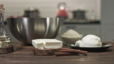 Evde güzel bir tatlı yapmak için gerekli malzemeler, ahşap bir masada uzanmak için. Sürgüde düzgün bir hareket var. Metal kase. Cam kase. Küçük tavuk tüyü.