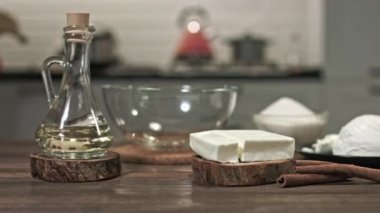 Evde güzel bir tatlı yapmak için gerekli malzemeler, ahşap bir masada uzanmak için. Sürgüde düzgün bir hareket var. Metal kase. Cam kase. Küçük tavuk tüyü.