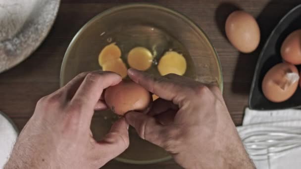 木制桌子上的顶级配料 生鸡蛋在玻璃碗里碎了 烤得太烂了为蛋糕做一个空气霜 相机滑块的运动与烹饪产品一起 — 图库视频影像