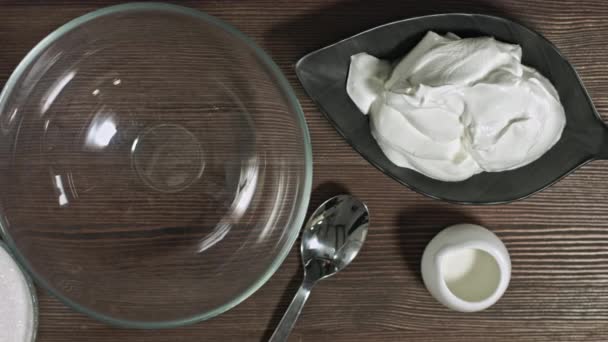 ガラスボウルに材料を追加します 男性の手はデザートを作る おいしいソフトサワークリームチーズ甘いクリーム 材料を練り込む 新鮮な天然自家製ヨーグルト エクレアのための詰め物 カードデザート — ストック動画
