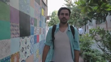 Gömlekli ve sırt çantalı genç, yakışıklı bir turist eski şehrin sokaklarında yürüyor. Güzel, eski Avrupa şehri. Dar cadde boyunca yürü. Omuzlarında bir sırt çantasıyla seyahat ediyor..