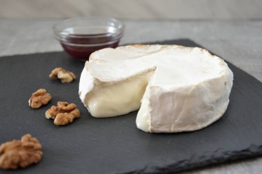 Erimiş gurme peynir, reçel ve taş masanın üzerine ceviz