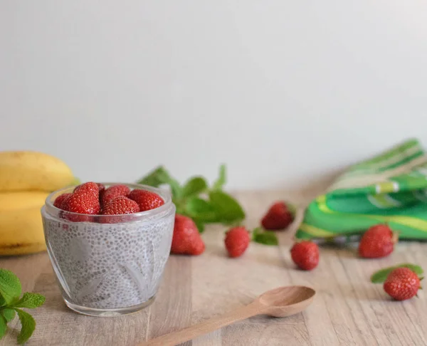 Ev yapımı sağlıklı kahvaltı. Gecede chia puding cam kavanozda çilek ile. 