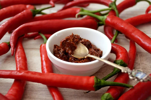 Kırmızı biber biber ve ahşap masa harissa sosu