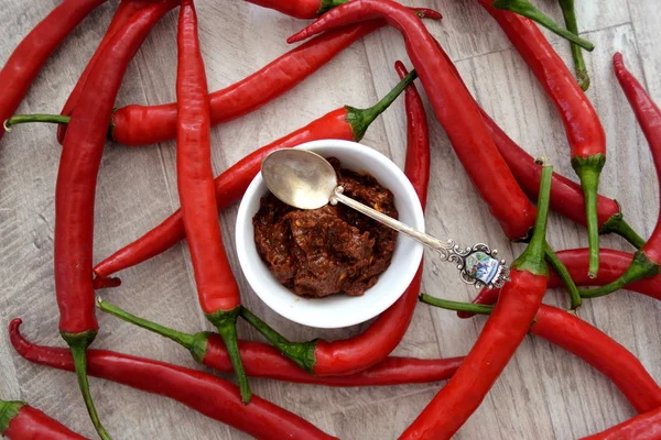 Kırmızı biber biber ve ahşap masa harissa sosu