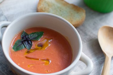 Soğuk yaz İspanyol domates yemek. Gazpacho çorbası ile zeytin yağı ve fesleğen yaprağı.