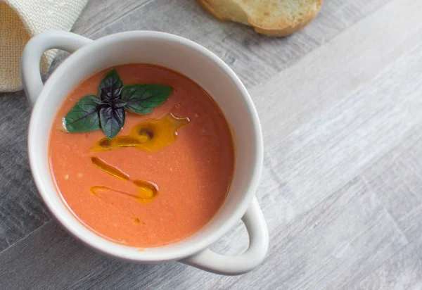 Soğuk yaz İspanyol domates yemek. Gazpacho çorbası ile zeytin yağı ve fesleğen yaprağı.