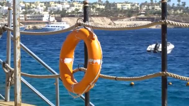 Оборудование для безопасности, спасательный буй или спасательный буй на деревянном пирсе на пляже — стоковое видео