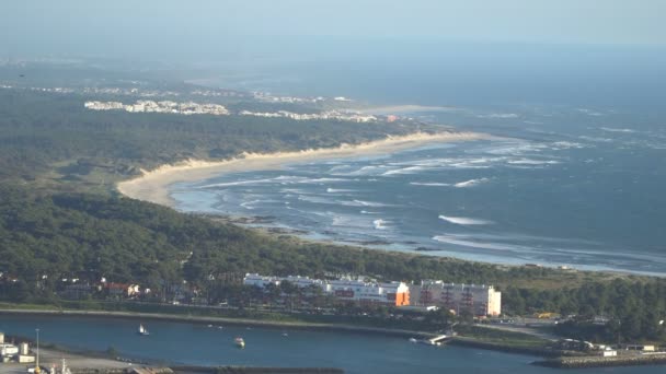 Вид сверху на красивый песчаный пляж с голубыми волнами, катящимися к берегу, некоторые камни присутствуют. Португалия — стоковое видео