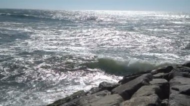 Mavi ile bir güzel okyanus kumlu plaj görünümünü birkaç taş sahile inişli çıkışlı dalgalar, mevcut.