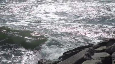 Mavi ile bir güzel okyanus kumlu plaj görünümünü birkaç taş sahile inişli çıkışlı dalgalar, mevcut.