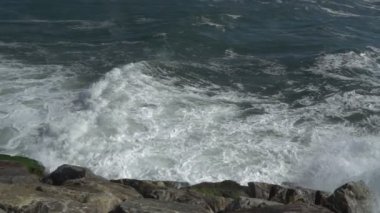 Mavi ile bir güzel okyanus kumlu plaj görünümünü birkaç taş sahile inişli çıkışlı dalgalar, mevcut.