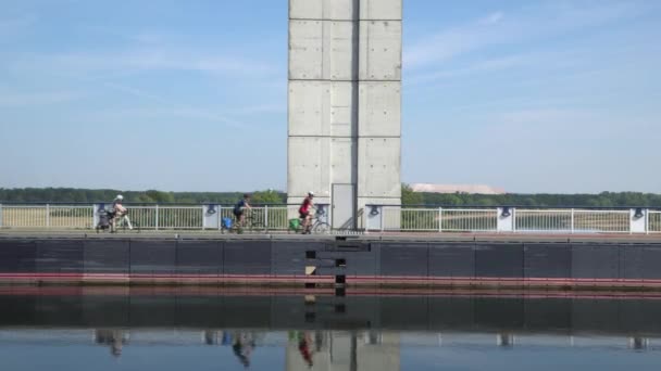 Group of people ride bicycles at water bridge, Magdeburg, Germany. 30.09.2018 — Stock Video