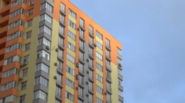 Bulutların arka planına karşı alt görünümü yüksek katlı binanın timelapse cephe