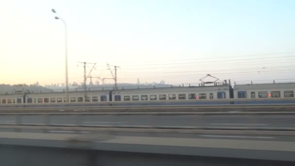 Die Eisenbahnlinien leuchten von den Sonnenstrahlen über dem Fluss Dnipro. kjiw — Stockvideo