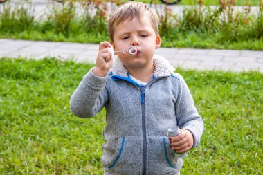 Sokakta bir çocuk sabun köpüğü üflüyor..