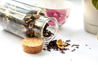 Bir fincan çay. Fincanda büyük çay yaprakları. Bir kutu çay. Meyveli büyük yaprak çayı.