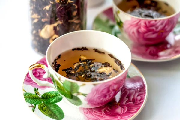 Cup of tea. Large tea leaves in a Cup. A can of tea. Large-leaf tea with fruit.