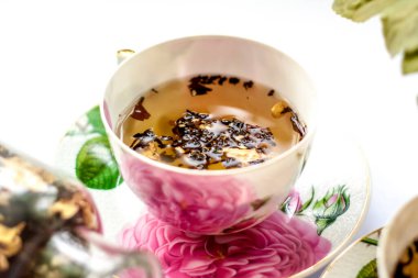 Bir fincan çay. Fincanda büyük çay yaprakları. Meyveli büyük yapraklı çay. Çay partisi..