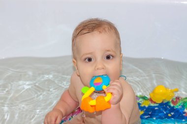 Çocuk banyoda banyo yapıyor. Suda oyunlar. Bir çocuğu yıkıyorum. Tuvaletteki oyuncaklar. Bir bebek portresi.