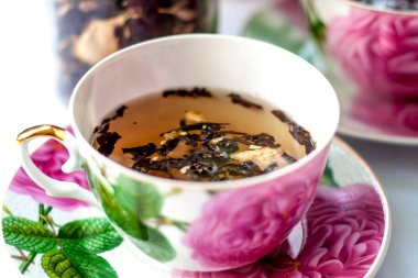 Bir fincan çay. Fincanda büyük çay yaprakları. Meyveli büyük yapraklı çay. Çay partisi..