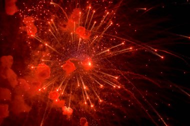 Selam dur. Karanlık gökyüzünde parlak, kırmızı havai fişekler. Gece havai fişekleri.