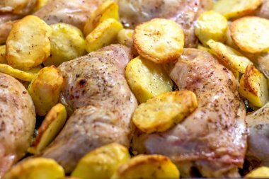  Fırında tavuk budu ve patates. Tavuklu patates halkaları. Bir tabak tavuk ve patates..